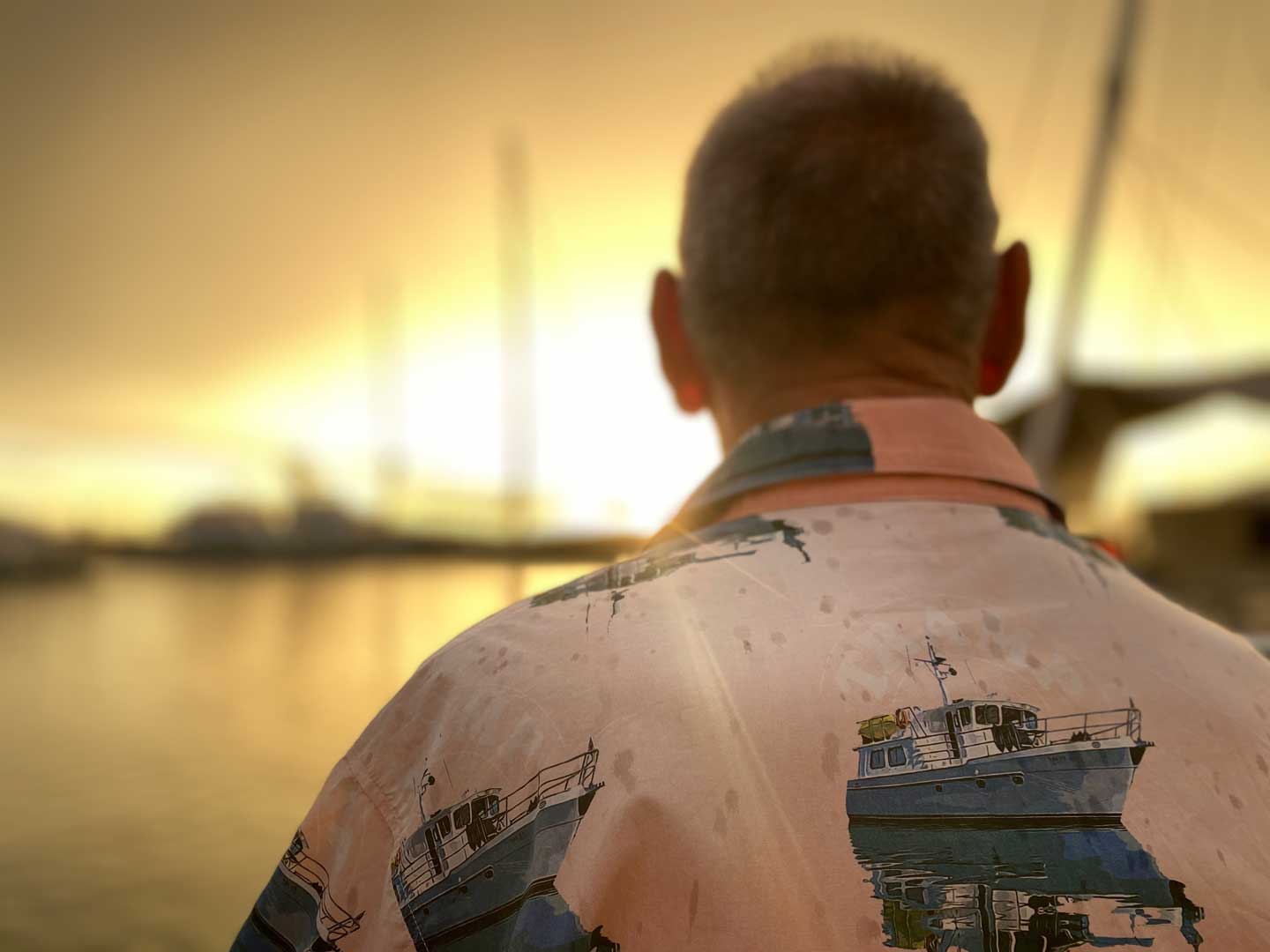 Captain Boatiful Watching the sunset in a rainshower in Borneo wearing a personalised hawaiian shirt featuring his boat